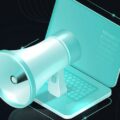 Ein Megafon Icon guckt auf einem Laptop Icon heraus und steht für das Thema Presse