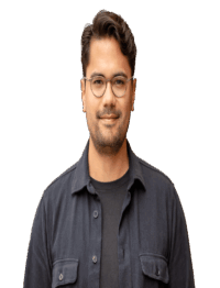 Ein junger Mann mit Brille und kurzem, dunklem Haar blickt ruhig in die Kamera; er trägt ein dunkles Hemd über einem schwarzen T-Shirt vor neutralem, transparentem Hintergrund.